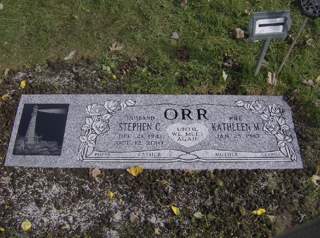 Grey flush marker with an etched lighthouse panel and carved roses