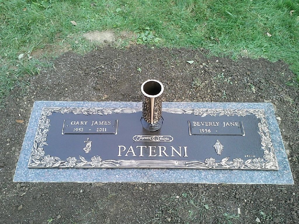 Bronze marker set on a grey granite base with a bronze vase