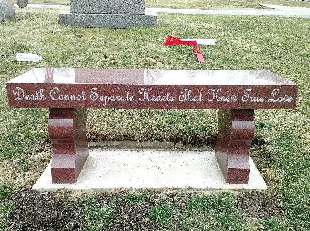 Red granite memorial bench lettered along the front edge